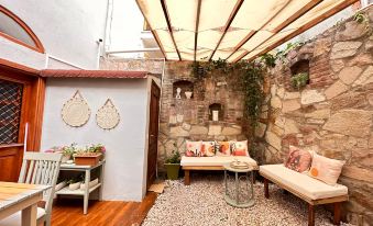 A small outdoor room with stone walls and an arched doorway that opens to the outside at Hanole Guest House