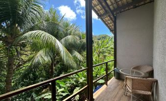 a balcony with a view of palm trees and a blue sky , creating a serene atmosphere at Pousada Simpatia da Ilha