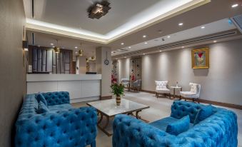 a modern hotel lobby with blue and white color scheme , including couches , chairs , and a dining table at Hampton by Hilton Kahramanmaras