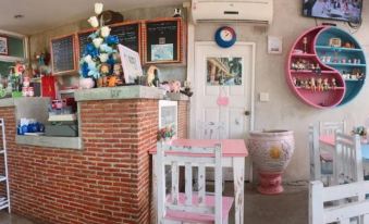 a pink and white dining area with a wooden table , chairs , and various items on the table at Tulip Place