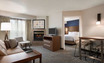 a hotel room with a living area , kitchen , and bedroom , all connected by a sliding door at Residence Inn West Springfield