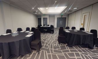 a conference room set up for a meeting , with several chairs arranged in rows and a table in the center at Village Hotel Birmingham Dudley