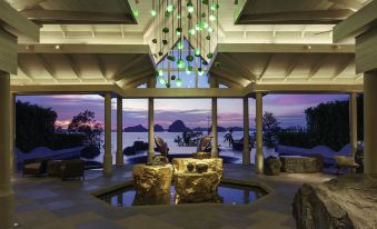 a luxurious hotel lobby with a waterfall and a large chandelier , providing a serene atmosphere at Banyan Tree Krabi