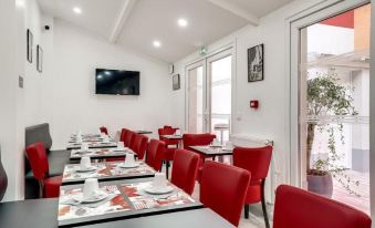 a dining room with red chairs and tables set up for a meal , along with a television mounted on the wall at Paris Hotel
