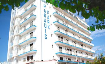 "a large white building with blue trim and the words "" hotel paradiis "" written on it" at Royal Beach
