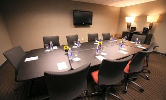 a conference room with a long table , multiple chairs , and a tv mounted on the wall at Fun City Resort Hotel