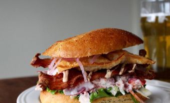 a close - up image of a delicious sandwich on a dining table , accompanied by a glass of beer at Oak Island Resort & Conference Centre