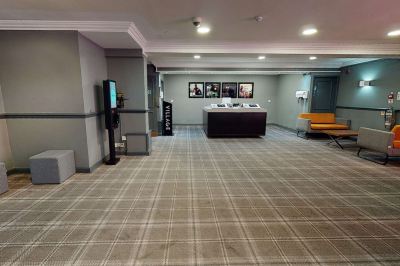 a large , empty room with a gray and white checkered carpet and a checkered floor at Village Hotel Liverpool