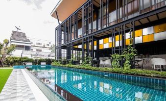 a modern building with a large swimming pool , surrounded by lush greenery and clear blue water at Blue Lagoon Hotel