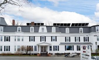 a large white house with a black roof and multiple solar panels on the roof at Sunset Hill House