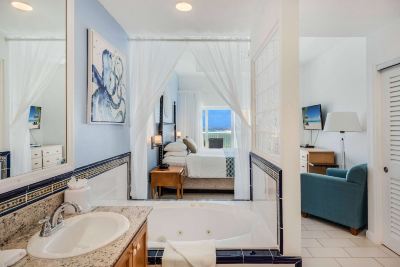 a luxurious bathroom with a bathtub and a large window , providing a view of the ocean at Wyndham Reef Resort Grand Cayman