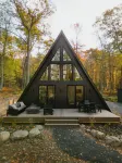 A modern A-frame, nestled in the woods with relaxing outdoor spaces and firepit.