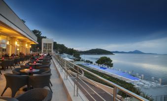 a rooftop restaurant with a view of the ocean and mountains , where several people are enjoying their meals at Vitality Hotel Punta