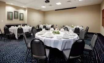 a conference room with round tables and chairs , each table is set with white tablecloths and napkins at Holiday Inn Hammond