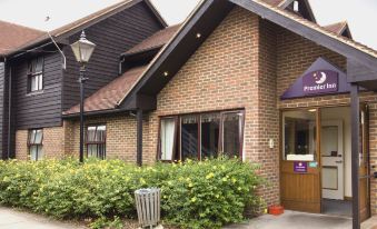 a brick building with a purple sign and bushes in front of it , creating a welcoming atmosphere at Sandhurst