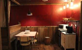 a small , cozy dining area with wooden walls , a table , chairs , and a microwave on the counter at Amish Country Comfort