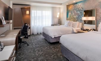 a hotel room with two beds , a desk , and a large painting on the wall at Courtyard Elmira Horseheads