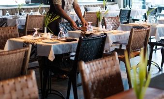 a man wearing a chef 's hat is preparing food in a restaurant , surrounded by tables and chairs at Matamanoa Island Resort