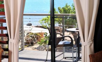 a room with a large window overlooking the ocean , providing a beautiful view of the beach at Groote Eylandt Lodge