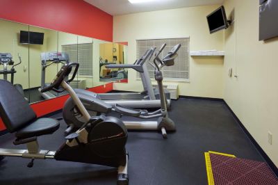 a gym with various exercise equipment , including treadmills and stationary bikes , is shown in this image at Country Inn & Suites by Radisson, Watertown, SD