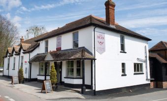 "a white building with a sign that says "" fly inn "" has a red awning and has a street sign in front of it" at The Selsey Arms