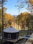 Elevated eclectic yurt with wrap-around porch, hot tub, and mountain view!