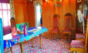 a room with wooden walls and furniture , a table in the center , and colorful carpeting at Dawn