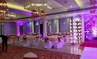 a large banquet hall with multiple round tables and chairs set up for a wedding reception at Regenta Central Jaipur
