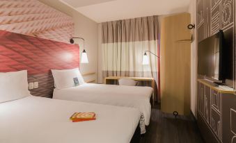 a modern hotel room with two beds , a nightstand , and a lamp , decorated with white bedding and curtains at Ibis Carlos Barbosa