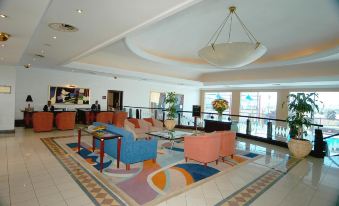 The lobby features couches, chairs, and side tables at Carnival City Hotel