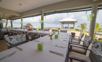 an outdoor dining area with tables and chairs set up for a meal , surrounded by trees and a gazebo at Saletoga Sands Resort & Spa