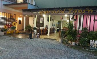 There is a store front with an entrance leading to an outdoor dining area, with a large table positioned in between two objects at Punyaporn Resort