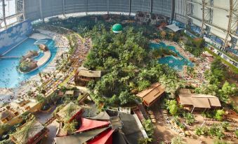a large indoor water park with various water slides and attractions , surrounded by a circular building at Tropical Islands