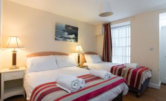 a hotel room with two beds , one on the left side and the other on the right side of the room at Marine Apartment