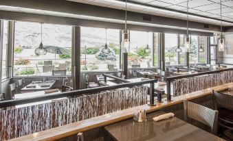 a modern restaurant with multiple dining tables and chairs , as well as a bar area at Holiday Inn Clarkston - Lewiston