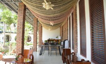 a modern living room with wooden furniture , including a dining table and chairs , as well as an outdoor patio area with benches and a table at Binh Minh Eco Lodge