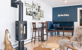 a cozy living room with a black wood stove , blue couch , and wooden coffee table at The North Hero House Inn & Restaurant