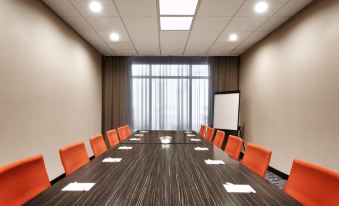 a conference room with a long wooden table surrounded by chairs , and a whiteboard on the wall at Fairfield Inn & Suites Houston League City