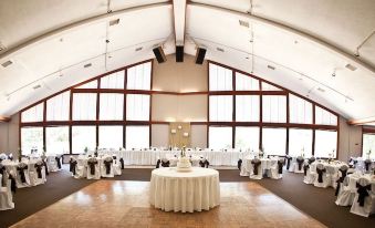 a large banquet hall with multiple tables and chairs set up for a wedding reception at Devil's Head Resort