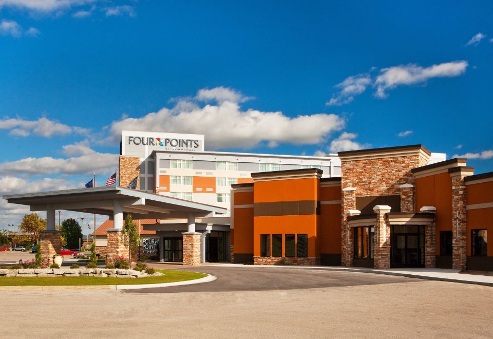 "a modern building with a large sign that reads "" four points "" prominently displayed on the front of the building" at Four Points by Sheraton Saginaw