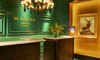 a hotel lobby with a green wall , a reception desk , and a painting on the wall at Marine Troon