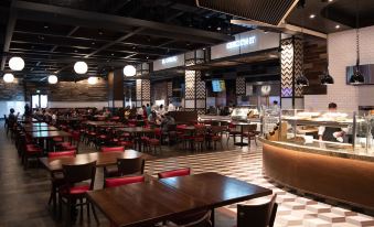 a large dining area with multiple tables and chairs , a bar , and people in the background at Soboba Casino Resort