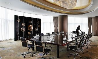 There is a conference room with a large table and chairs in the middle, as well as an adjacent office space at Sofitel Guangzhou Sunrich