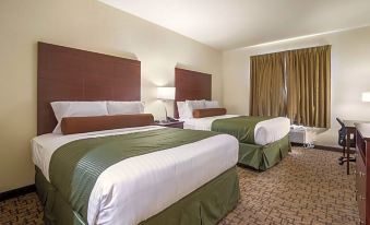 a hotel room with two beds , one on the left and one on the right side of the room at Cobblestone Hotel & Suites - Victor