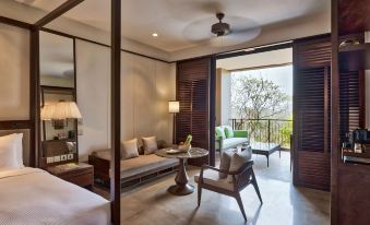a modern living room with a couch , chairs , and a tv . also a balcony overlooking the outdoors at Hilton Goa Resort