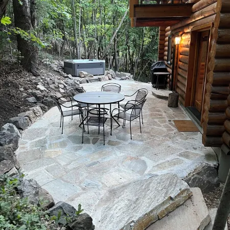 Cozy log cabin secluded in a mountain forest with hot tub, sauna, private patio.