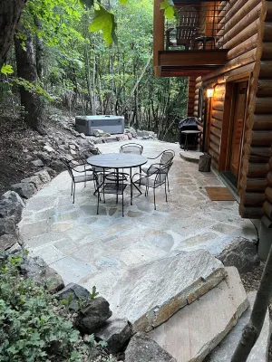 Cozy log cabin secluded in a mountain forest with hot tub, sauna, private patio.