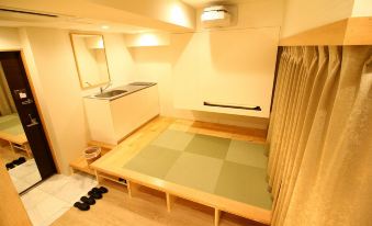 A small room with wooden floors and an area rug on the floor next to it at Sakura Cross Hotel Akihabara