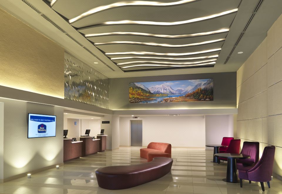 a modern hotel lobby with a large painting on the wall and a reception desk at Wyndham Garden i-City