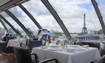 a dining room with a table set for two people , featuring white tablecloths and chairs at Hotel the Peninsula Paris